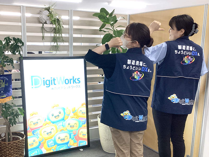 生産管理システムアイプロダブルのロゴ入りベストを着る社員たち